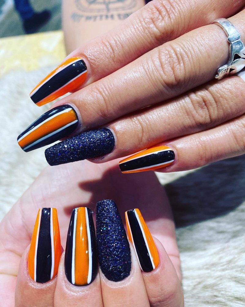 Orange and black striped coffin nails with glitter accent by Pleasant Nails & Spa
